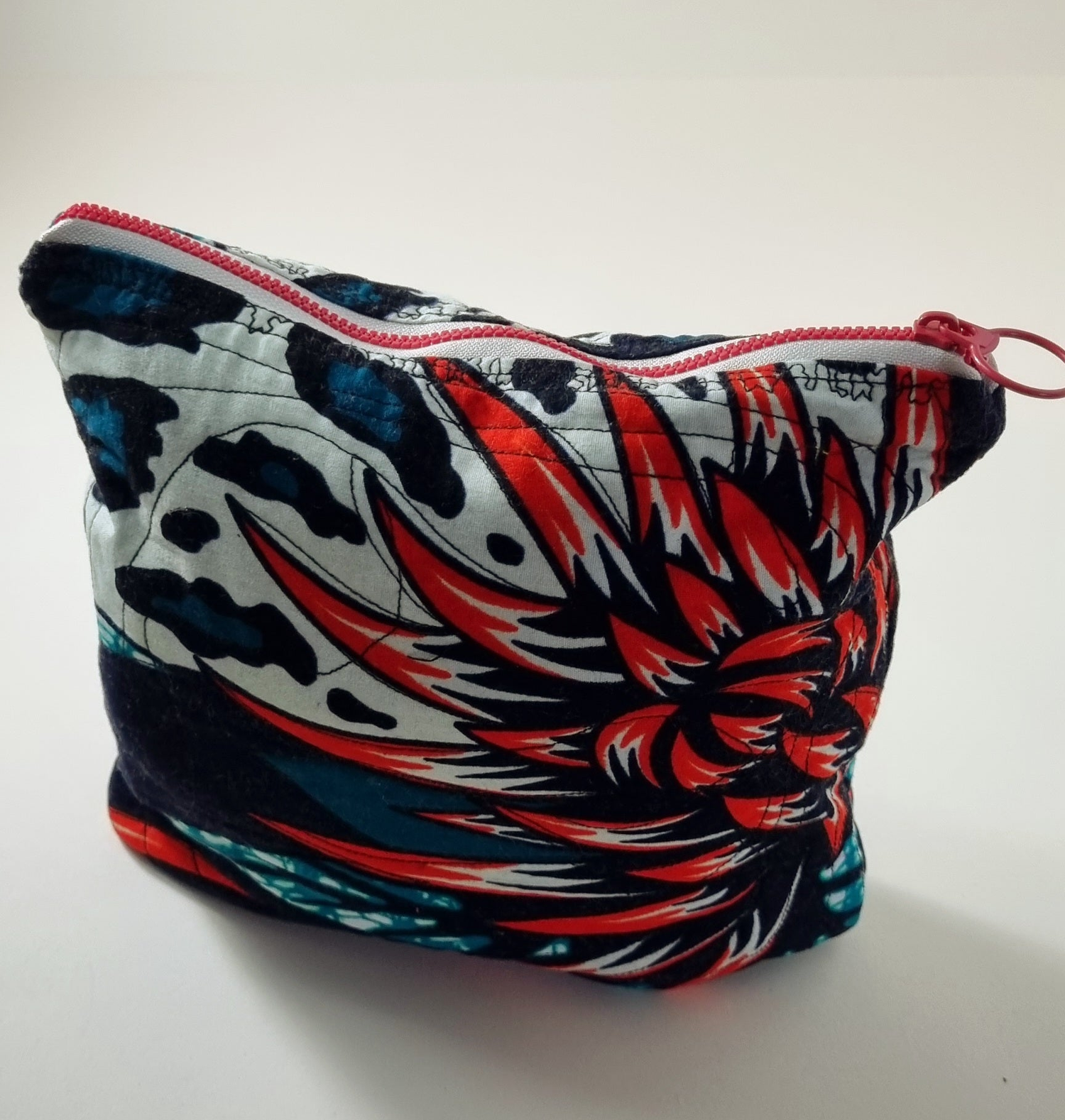 Hand holding 2 batik zipped pouches