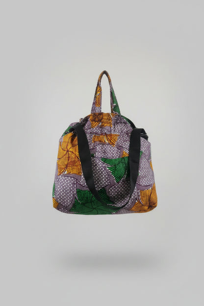Fans and Dots cotton market bag in purple, green and golden yellow, with fabric handles and a black shoulder strap.