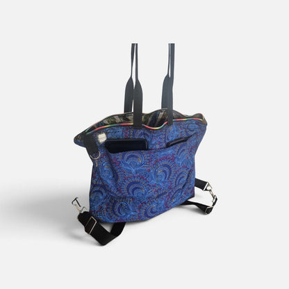 Blue Peacocks Traveller bag with blue paisley fabric, black folded handles, outer patch pockets and detachable straps.