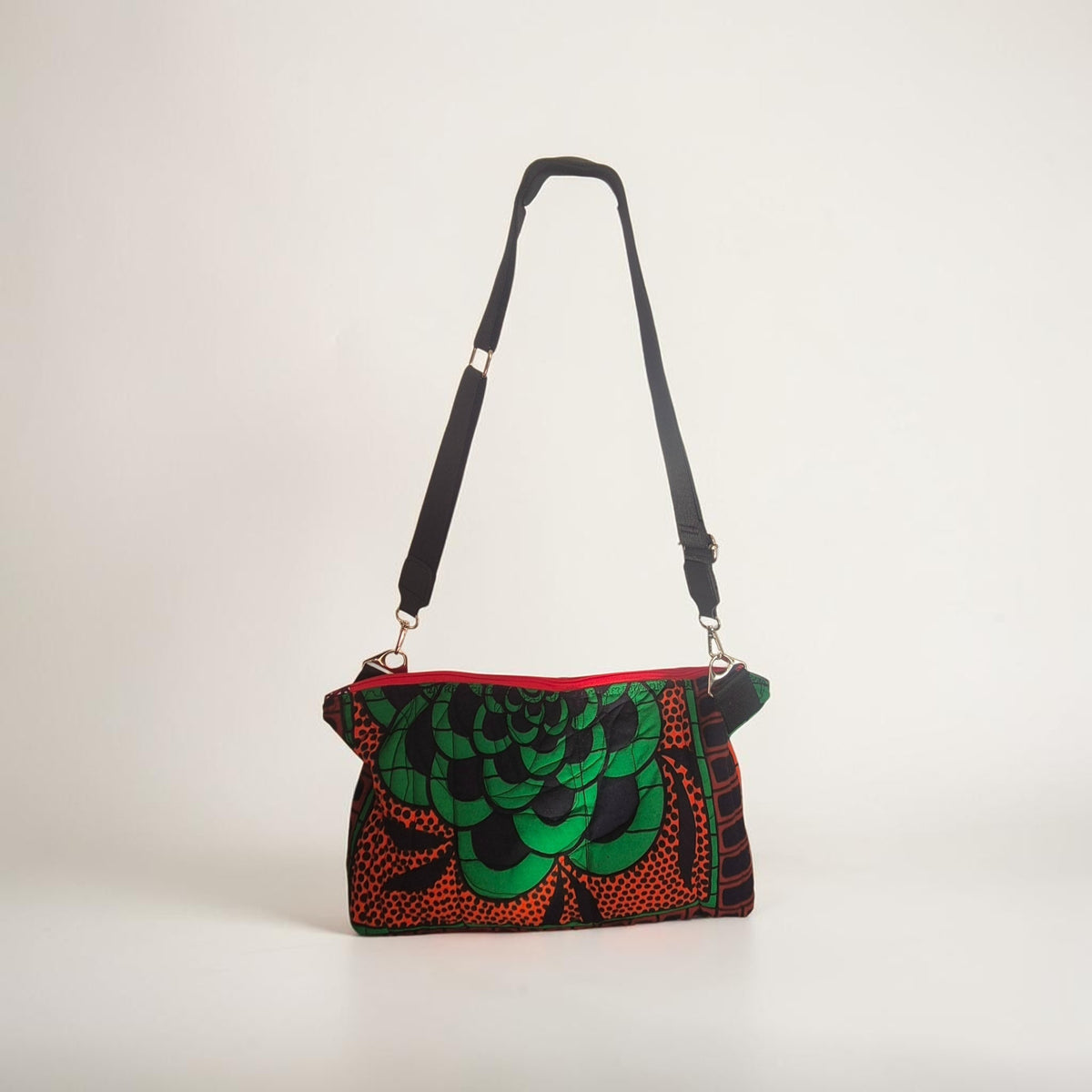 Hibiscus & Sunflower quilted crossbody bag standing upright with its full black adjustable strap visible.