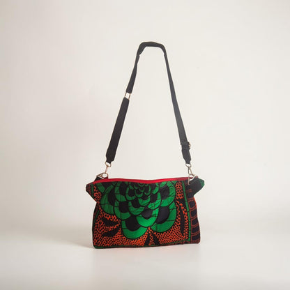 Hibiscus & Sunflower quilted crossbody bag standing upright with its full black adjustable strap visible.