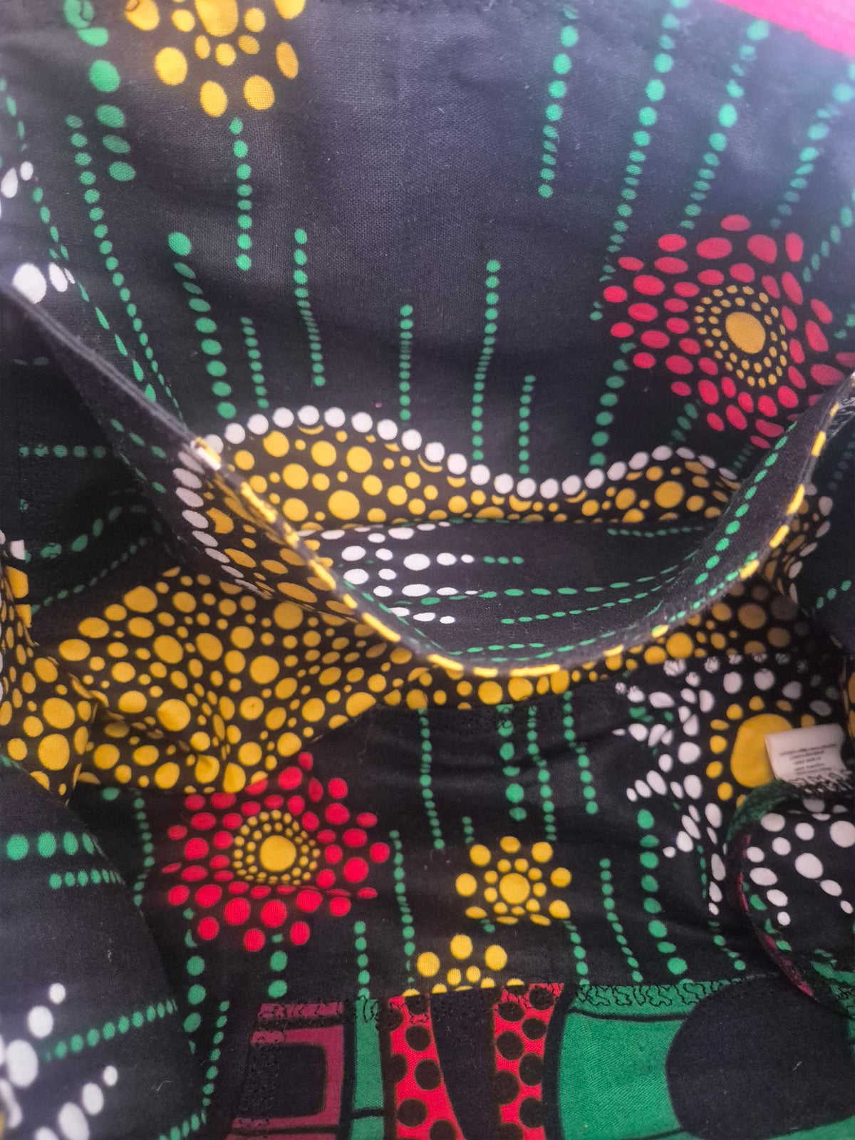 Close-up of an interior patch pocket in the Hibiscus & Sunflower bag, with yellow, white and green dotted floral lining.