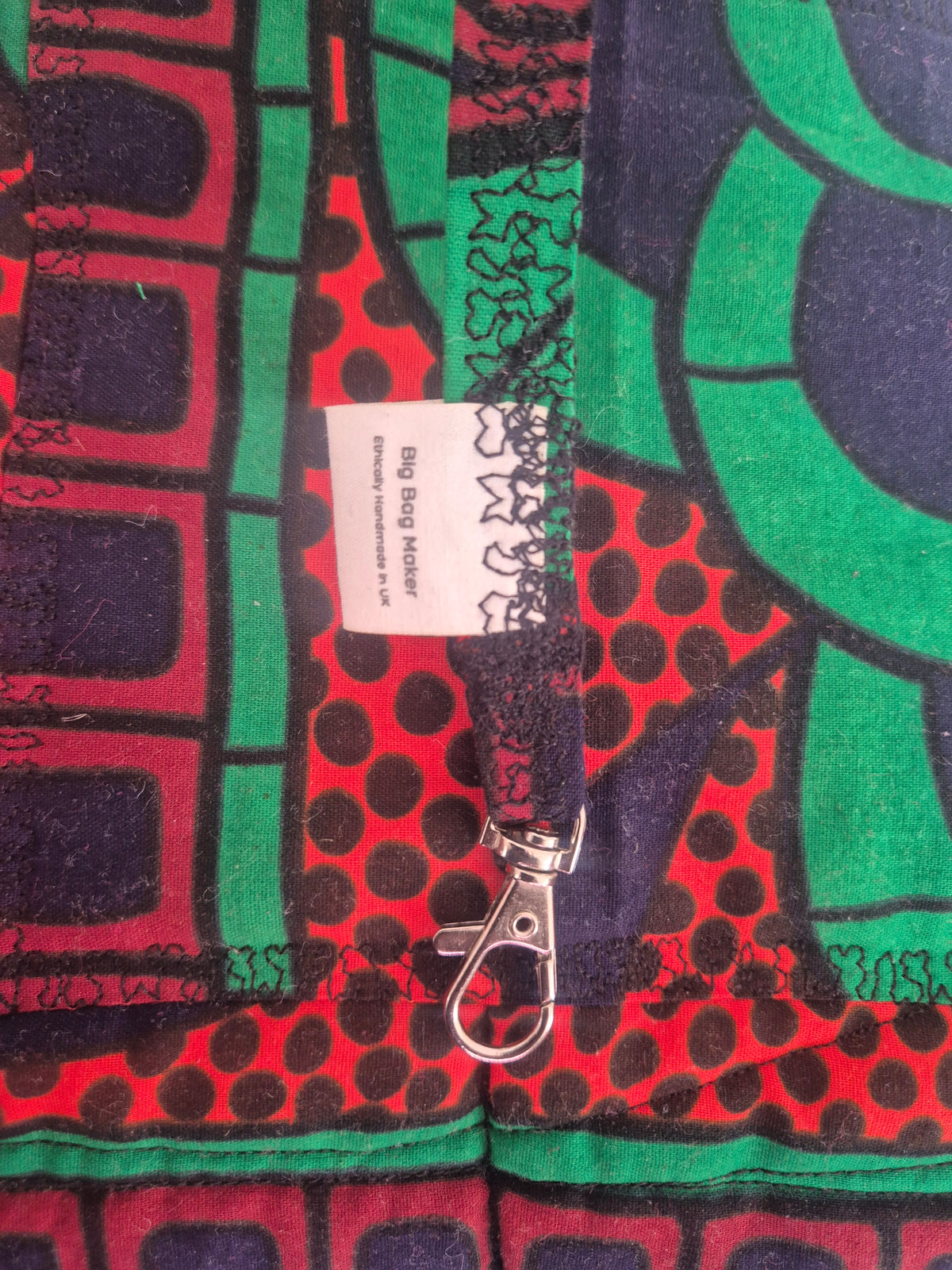 Close-up of the fabric key loop, silver-tone swivel clasp and Big Bag Maker label inside the Hibiscus & Sunflower bag.