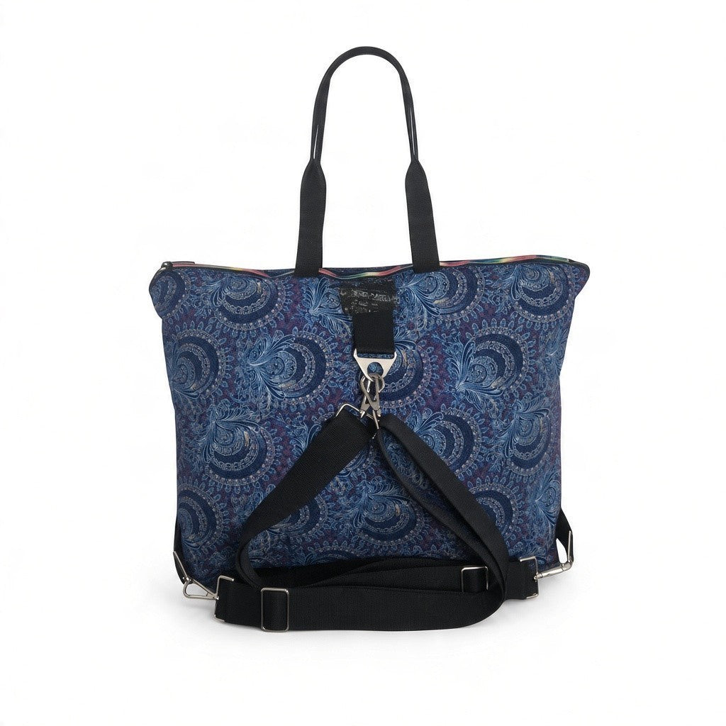 Rear of the blue paisley Traveller bag showing detachable black backpack straps, adjusters and silver-tone clips.