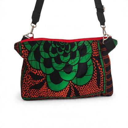 Front view of the Hibiscus & Sunflower quilted crossbody bag, with green and coral floral print, red zip and black strap.