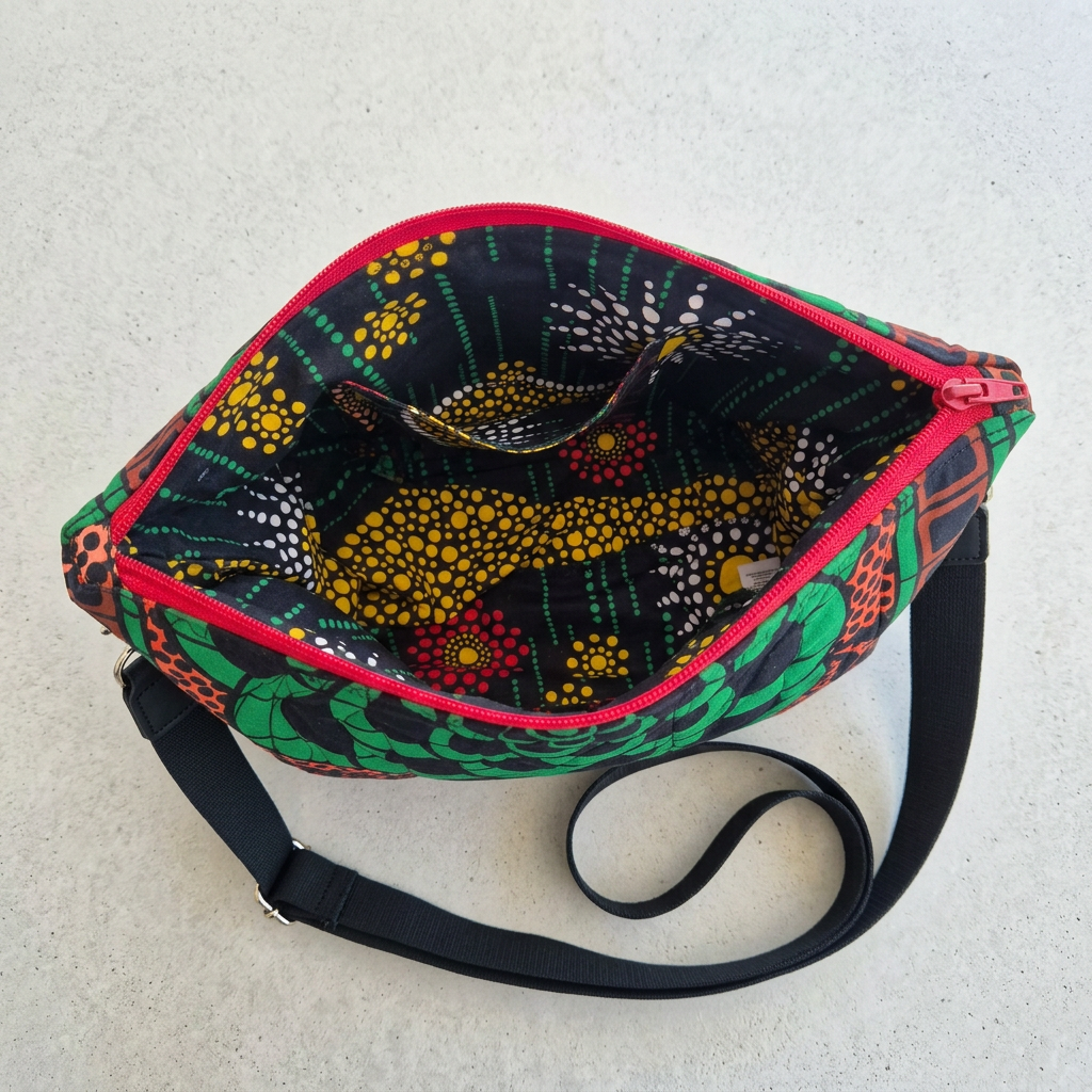 Open Hibiscus & Sunflower bag showing the patterned lining and interior patch pocket, with the black strap beside it.