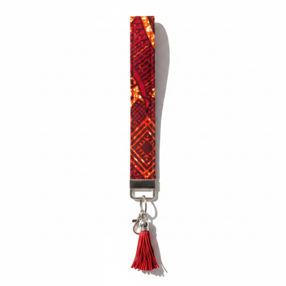 African wax print key fob wristlet in red and orange geometric Dutch wax print with silver lobster clasp and red tassel charm, white background